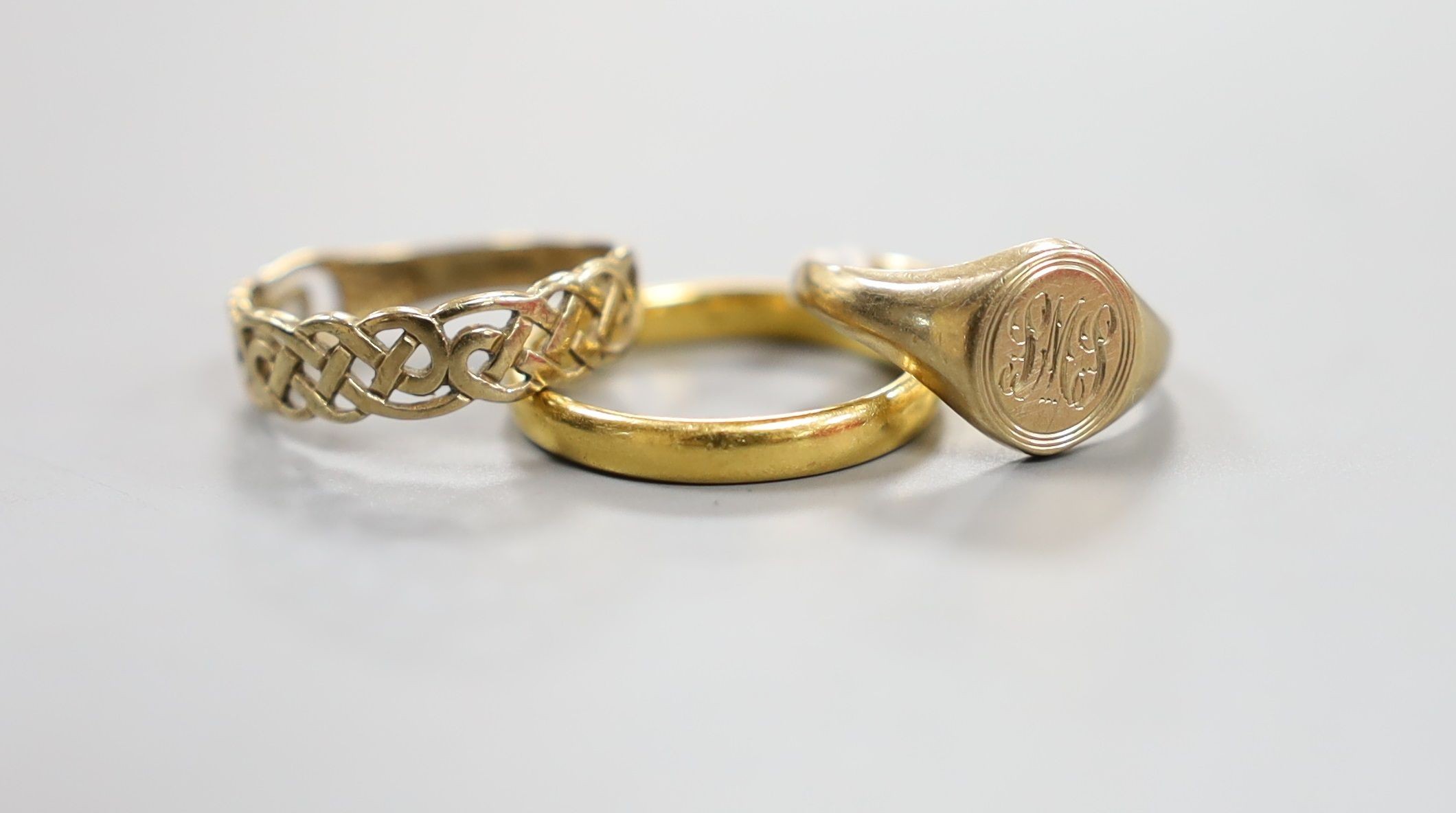 A modern 22ct gold wedding band, 3.3 grams and two 9ct gold rings including signet, 4.2 grams.